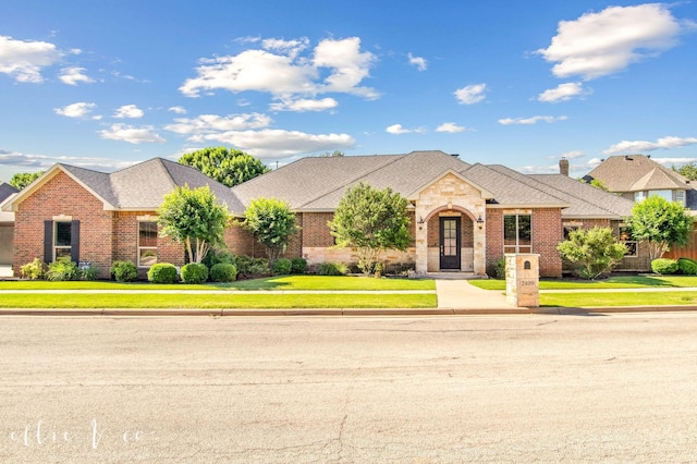 2409 Lynbrook Dr, Abilene, TX 79606 - french country inspired facade featuring brick siding, a front yard, and a shingled roof