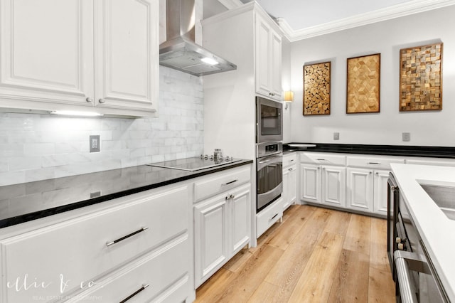 2409 Lynbrook Dr, Abilene, TX 79606 - kitchen featuring wall chimney exhaust hood, stainless steel appliances, dark countertops, white cabinets, and ornamental molding