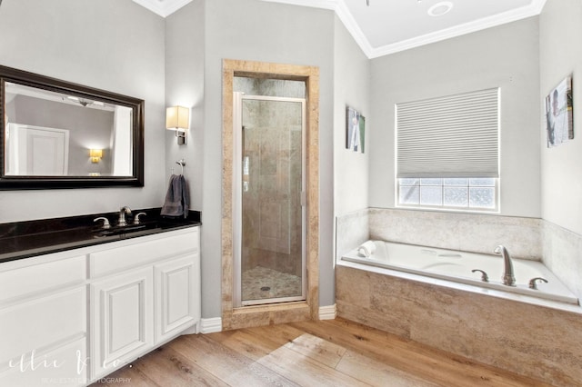2409 Lynbrook Dr, Abilene, TX 79606 - bathroom featuring ornamental molding, a stall shower, wood finished floors, a garden tub, and vanity
