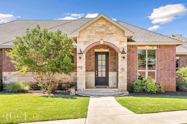 2409 Lynbrook Dr, Abilene, TX 79606 - entrance to property with stone siding, a yard, roof with shingles, and brick siding