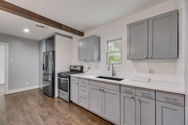 317 Edgefield Dr, Garland, TX 75040 - kitchen with stainless steel appliances, gray cabinets, a sink, tasteful backsplash, and beamed ceiling