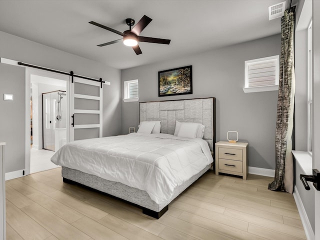 13333 Hedgebrook Pl, Fort Worth, TX 76008 - bedroom with a barn door, light wood-type flooring, ceiling fan, baseboards, and ensuite bath