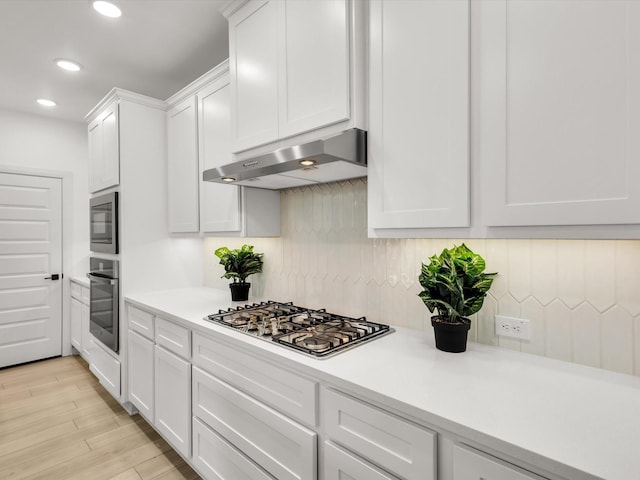 13333 Hedgebrook Pl, Fort Worth, TX 76008 - kitchen featuring under cabinet range hood, appliances with stainless steel finishes, backsplash, light countertops, and white cabinets