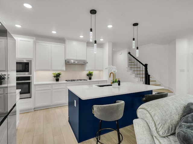 13333 Hedgebrook Pl, Fort Worth, TX 76008 - kitchen featuring stainless steel oven, a sink, built in microwave, under cabinet range hood, and light wood-style floors