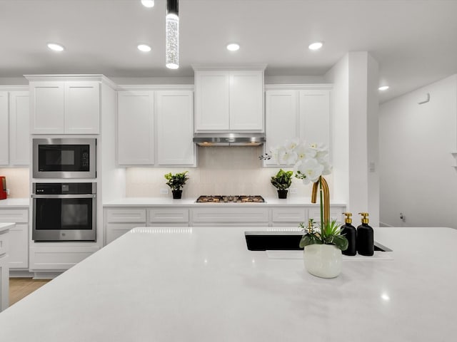 13333 Hedgebrook Pl, Fort Worth, TX 76008 - kitchen featuring appliances with stainless steel finishes, light countertops, white cabinets, tasteful backsplash, and recessed lighting