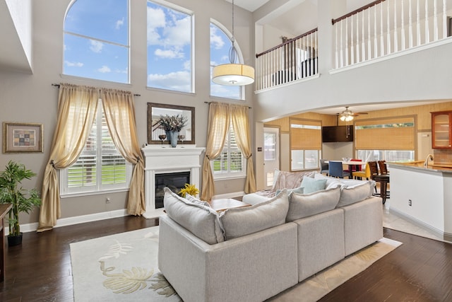 269 Love Bird Ln, Murphy, TX 75094 - living room with a ceiling fan, a glass covered fireplace, a high ceiling, wood finished floors, and baseboards