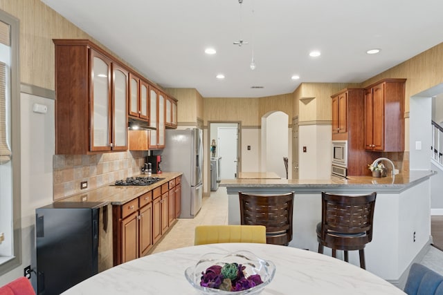 269 Love Bird Ln, Murphy, TX 75094 - kitchen with recessed lighting, stainless steel appliances, glass insert cabinets, decorative backsplash, and light stone countertops