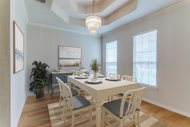126 Oakbend Dr, Coppell, TX 75019 - dining room with a tray ceiling, light wood finished floors, a chandelier, plenty of natural light, and ornamental molding
