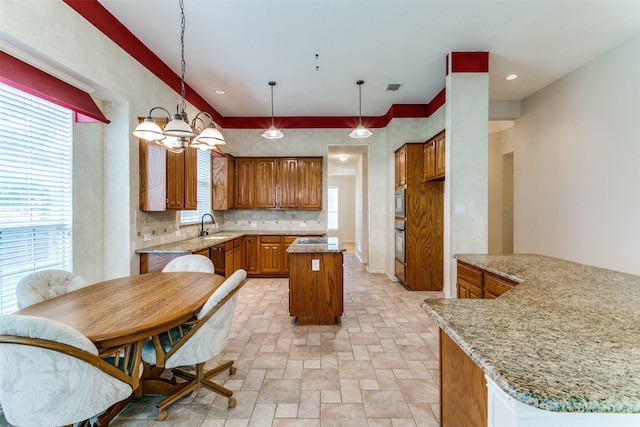 126 Oakbend Dr, Coppell, TX 75019 - kitchen featuring a sink, wall oven, brown cabinets, a center island, and plenty of natural light