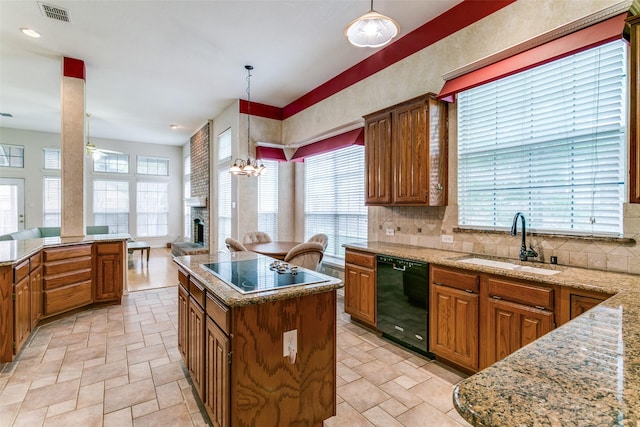 126 Oakbend Dr, Coppell, TX 75019 - kitchen featuring black appliances, a sink, a center island, brown cabinetry, and tasteful backsplash