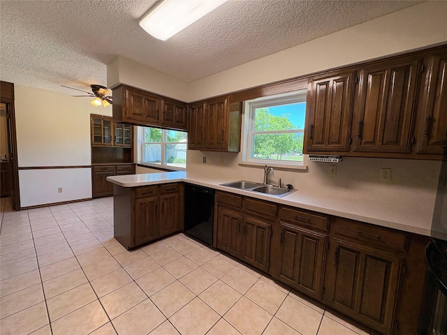 327 Shadowwood Trl, Ovilla, TX 75154 - kitchen with black dishwasher, a textured ceiling, a sink, light countertops, and a peninsula