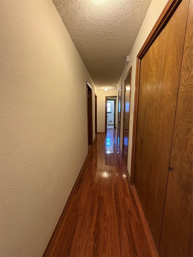327 Shadowwood Trl, Ovilla, TX 75154 - hall featuring dark wood finished floors, a textured ceiling, and baseboards