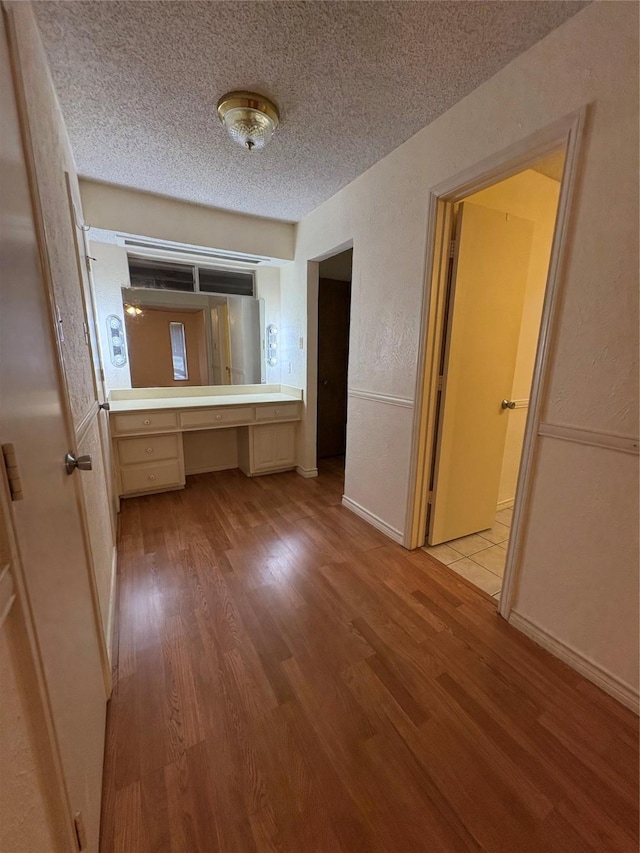 327 Shadowwood Trl, Ovilla, TX 75154 - hall with light wood-style flooring, a desk, and a textured ceiling