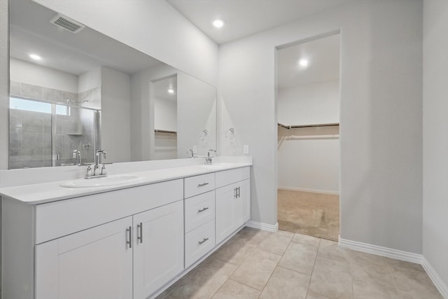 6112 Fire Water Dr, Fort Worth, TX 76179 - bathroom featuring a walk in closet, double vanity, a shower stall, baseboards, and tile patterned flooring