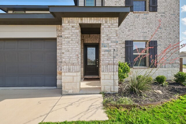 6112 Fire Water Dr, Fort Worth, TX 76179 - entrance to property with brick siding, concrete driveway, stone siding, and a garage