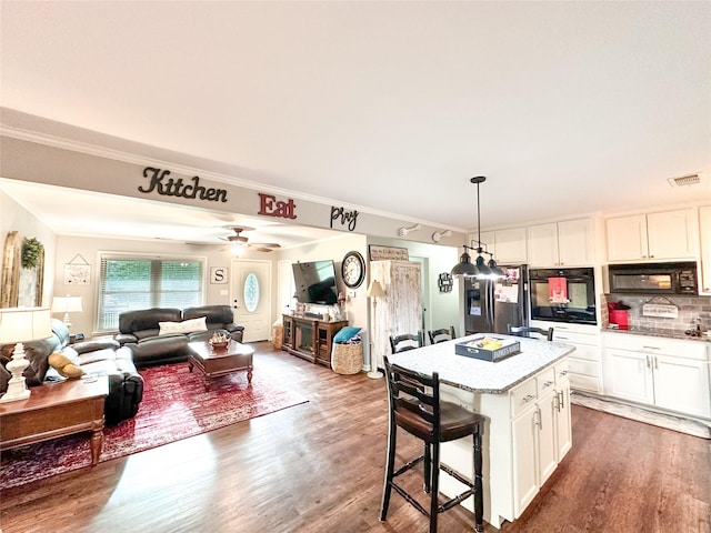 812 Walters St, Frankston, TX 75763 - kitchen with black appliances, white cabinets, wood finished floors, a kitchen bar, and ornamental molding