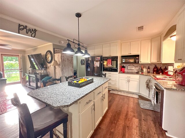 812 Walters St, Frankston, TX 75763 - kitchen with black appliances, light stone countertops, white cabinetry, dark wood-style flooring, and a center island