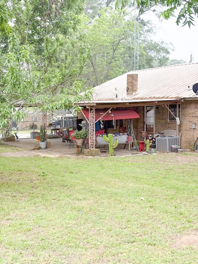 812 Walters St, Frankston, TX 75763 - back of house with a patio, a lawn, and metal roof