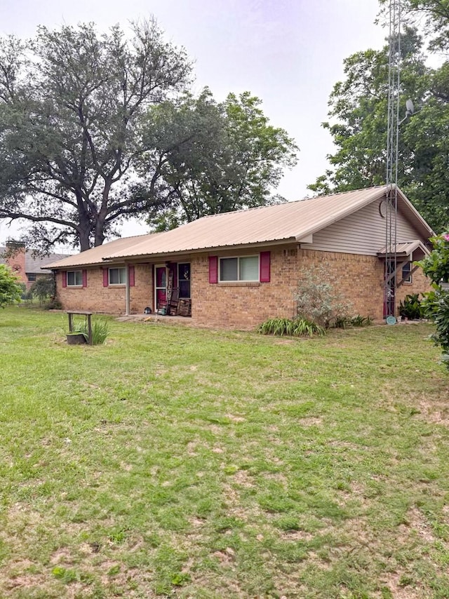 812 Walters St, Frankston, TX 75763 - view of front of home with brick siding, a front lawn, and metal roof