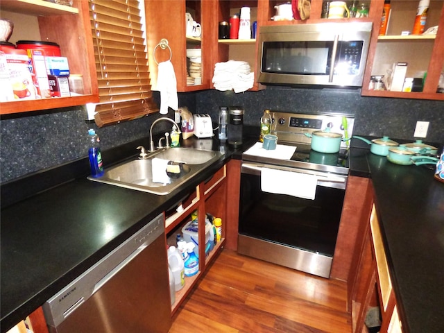 1075 County Road 436, Eastland, TX 76448 - kitchen featuring appliances with stainless steel finishes, wood finished floors, decorative backsplash, and a sink