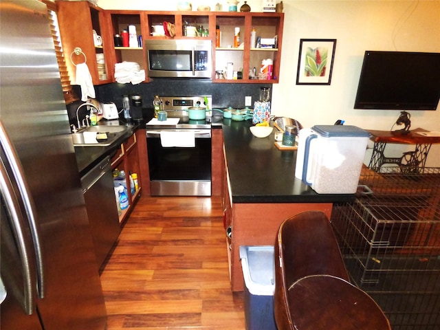 1075 County Road 436, Eastland, TX 76448 - kitchen with appliances with stainless steel finishes, wood finished floors, a sink, dark countertops, and open shelves