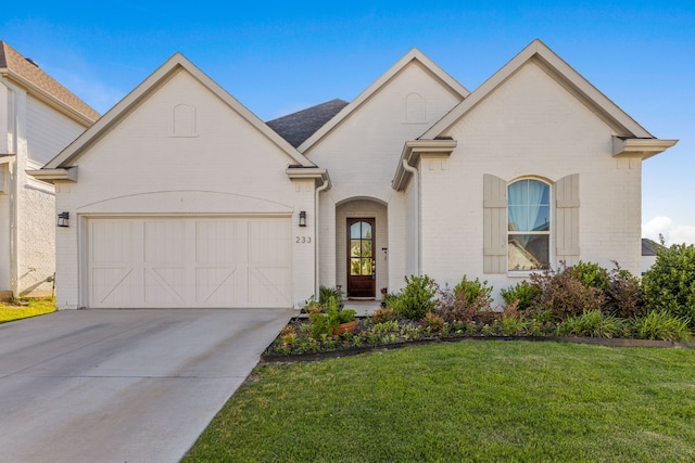 233 Observation Dr N, Aledo, TX 76008 - french country inspired facade with brick siding, an attached garage, a front lawn, and concrete driveway