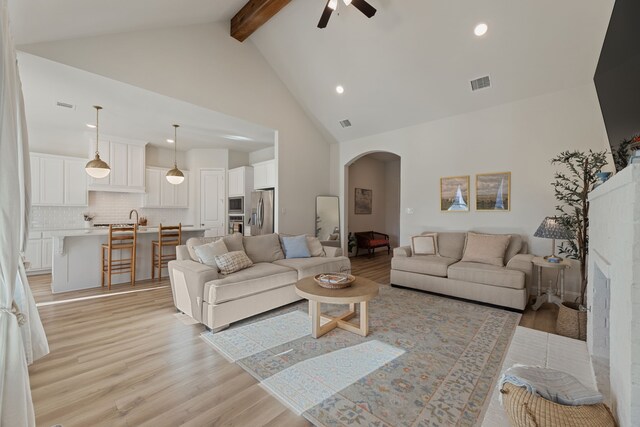 233 Observation Dr N, Aledo, TX 76008 - living area with arched walkways, light wood finished floors, ceiling fan, beamed ceiling, and high vaulted ceiling