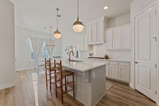 233 Observation Dr N, Aledo, TX 76008 - kitchen with a sink, tasteful backsplash, a kitchen island with sink, stainless steel gas cooktop, and light countertops