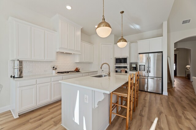 233 Observation Dr N, Aledo, TX 76008 - kitchen featuring appliances with stainless steel finishes, a sink, arched walkways, tasteful backsplash, and recessed lighting