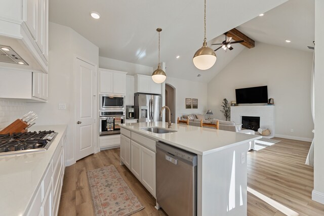 233 Observation Dr N, Aledo, TX 76008 - kitchen featuring stainless steel appliances, a sink, light wood-style floors, arched walkways, and a ceiling fan
