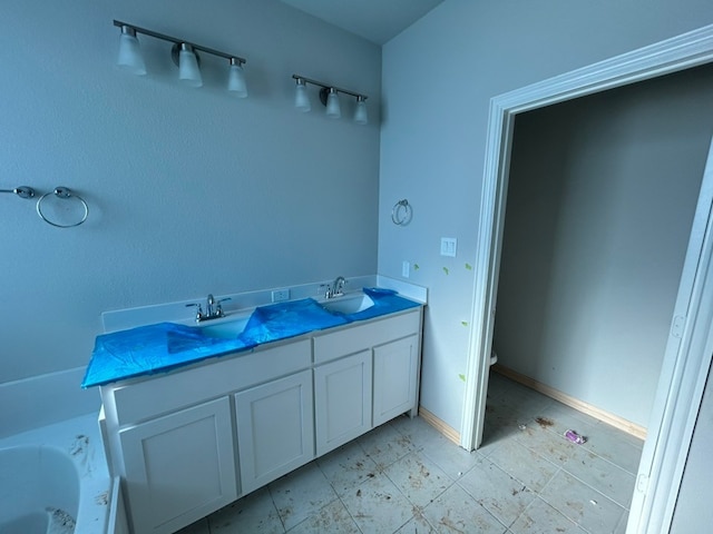 3514 Columbus St, Gainesville, TX 76240 - bathroom featuring a bathtub, toilet, double vanity, and baseboards