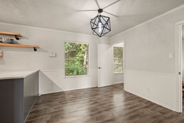 6455 Waverly Way, Fort Worth, TX 76116 - unfurnished dining area featuring a textured ceiling, crown molding, dark wood-style flooring, and a wainscoted wall