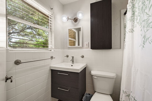 6455 Waverly Way, Fort Worth, TX 76116 - bathroom featuring tile walls, healthy amount of natural light, toilet, vanity, and wainscoting