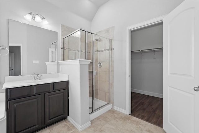 7802 Lindsey Dr, Rowlett, TX 75088 - full bath with a shower stall, vanity, a walk in closet, baseboards, and lofted ceiling