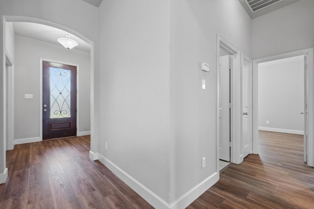 7802 Lindsey Dr, Rowlett, TX 75088 - foyer entrance with arched walkways, dark wood-style floors, and baseboards