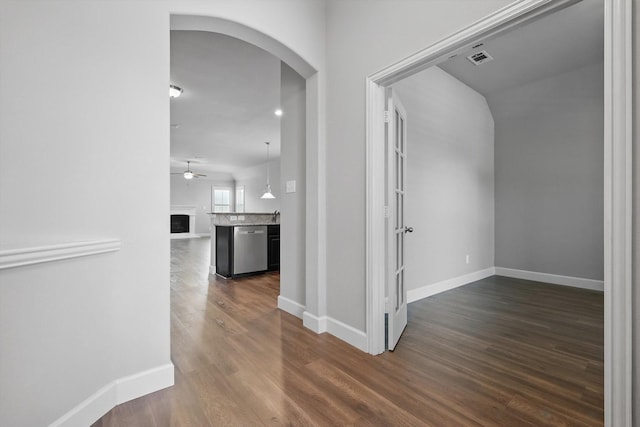 7802 Lindsey Dr, Rowlett, TX 75088 - hallway featuring arched walkways, dark wood-style flooring, and baseboards