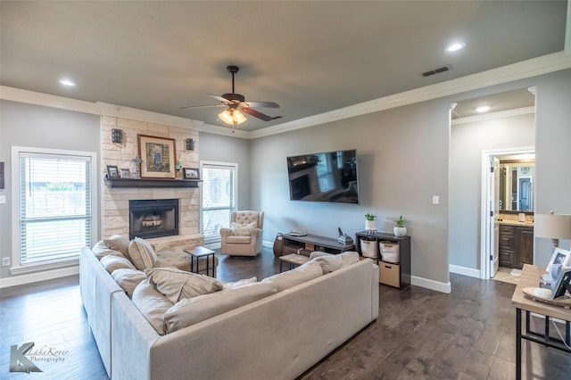 349 Mill Creek Dr, Abilene, TX 79602 - living area featuring crown molding, dark wood-style floors, baseboards, a ceiling fan, and a stone fireplace