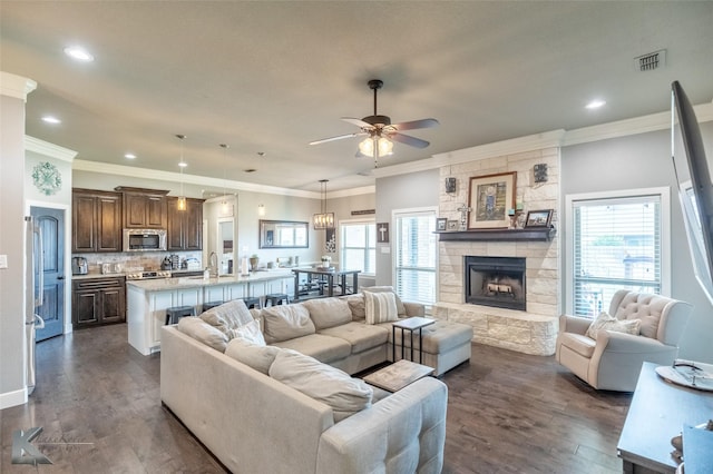 349 Mill Creek Dr, Abilene, TX 79602 - living area with a ceiling fan, dark wood finished floors, a stone fireplace, ornamental molding, and recessed lighting