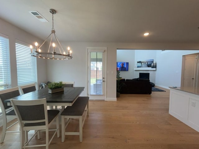 501 Upper Falls Ln, Mansfield, TX 76063 - dining room featuring a chandelier, light wood-style flooring, recessed lighting, baseboards, and a fireplace