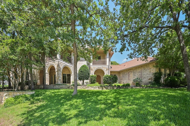 1 Hamper Ct, Trophy Club, TX 76262 - view of front facade featuring stone siding, a front lawn, a tile roof, and a balcony