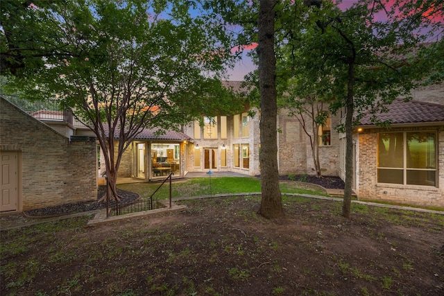 1 Hamper Ct, Trophy Club, TX 76262 - back of house at dusk with a tile roof, a patio, and brick siding