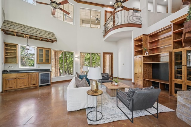 1 Hamper Ct, Trophy Club, TX 76262 - living room featuring ceiling fan, beverage cooler, a towering ceiling, wet bar, and baseboards