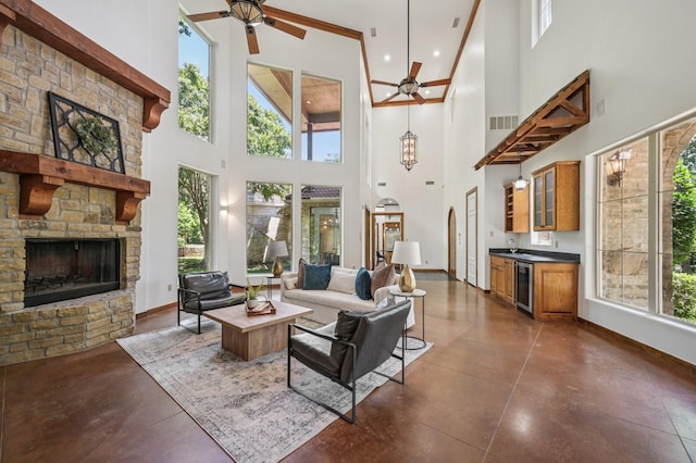 1 Hamper Ct, Trophy Club, TX 76262 - living room with wine cooler, a stone fireplace, a towering ceiling, a ceiling fan, and finished concrete floors