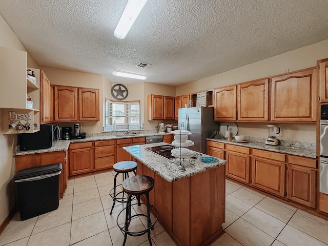 1665 Fm 2452, Corsicana, TX 75110 - kitchen featuring black appliances, a kitchen island, a textured ceiling, a sink, and light tile patterned floors