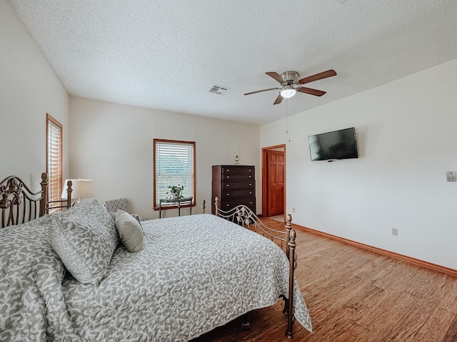 1665 Fm 2452, Corsicana, TX 75110 - bedroom with wood finished floors, a textured ceiling, a ceiling fan, and baseboards