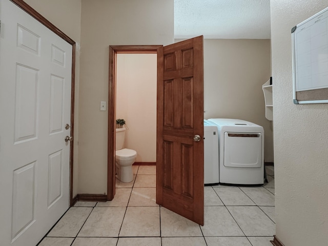 1665 Fm 2452, Corsicana, TX 75110 - washroom featuring washer and clothes dryer, light tile patterned floors, and a textured ceiling