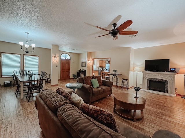 1665 Fm 2452, Corsicana, TX 75110 - living room featuring a fireplace, wood finished floors, a ceiling fan, baseboards, and a chandelier