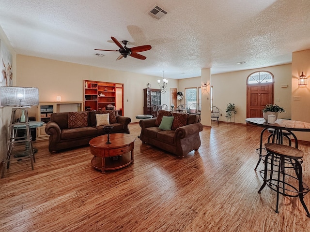 1665 Fm 2452, Corsicana, TX 75110 - living room featuring wood finished floors, a textured ceiling, ceiling fan, and a chandelier