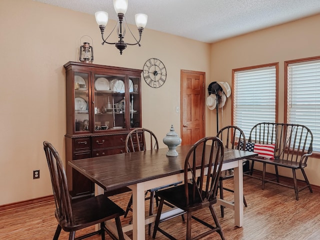1665 Fm 2452, Corsicana, TX 75110 - dining room with light wood-style floors, a chandelier, a textured ceiling, and baseboards
