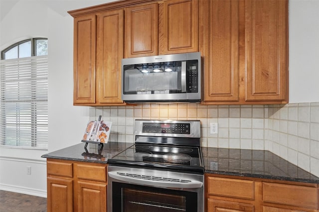 7602 Bridge Water Cir, Frisco, TX 75034 - kitchen featuring appliances with stainless steel finishes, brown cabinetry, backsplash, and dark stone counters